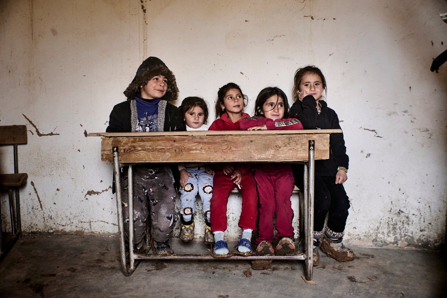 Jinwar, 12 février 2025 – Des élèves dans l'école de Jinwar. Jilan (au centre) est arrivée au village avec sa mère en 2024. Son père, un homme de l’État islamique, s'est marié de force avec sa mère, une Yezidie de Sinjar, en Irak. La fillette et sa mère ont été capturées lors de la chute du dernier bastion du califat, à Baghouz, en 2019. Le père aurait été tué au combat. Accusées par erreur d’appartenir à l'organisation terroriste, elles ont ensuite passé cinq ans dans le camp d'Al Hol, cachant leurs véritable identité yezidie par peur de représailles des autres prisonnières. Elles ont finalement été libérées en 2024.