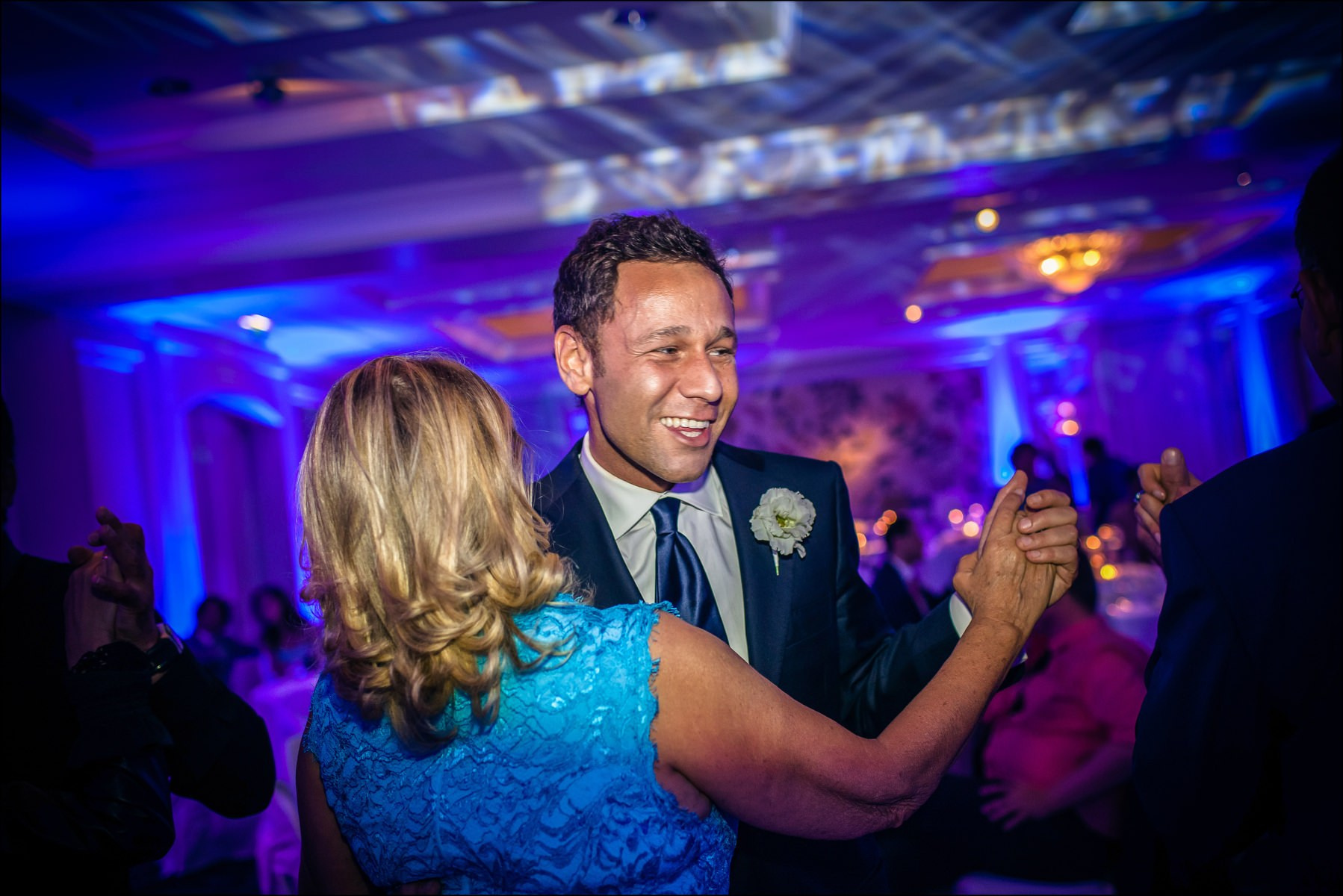 Groom dancing with guest during reception Four Seasons Prague