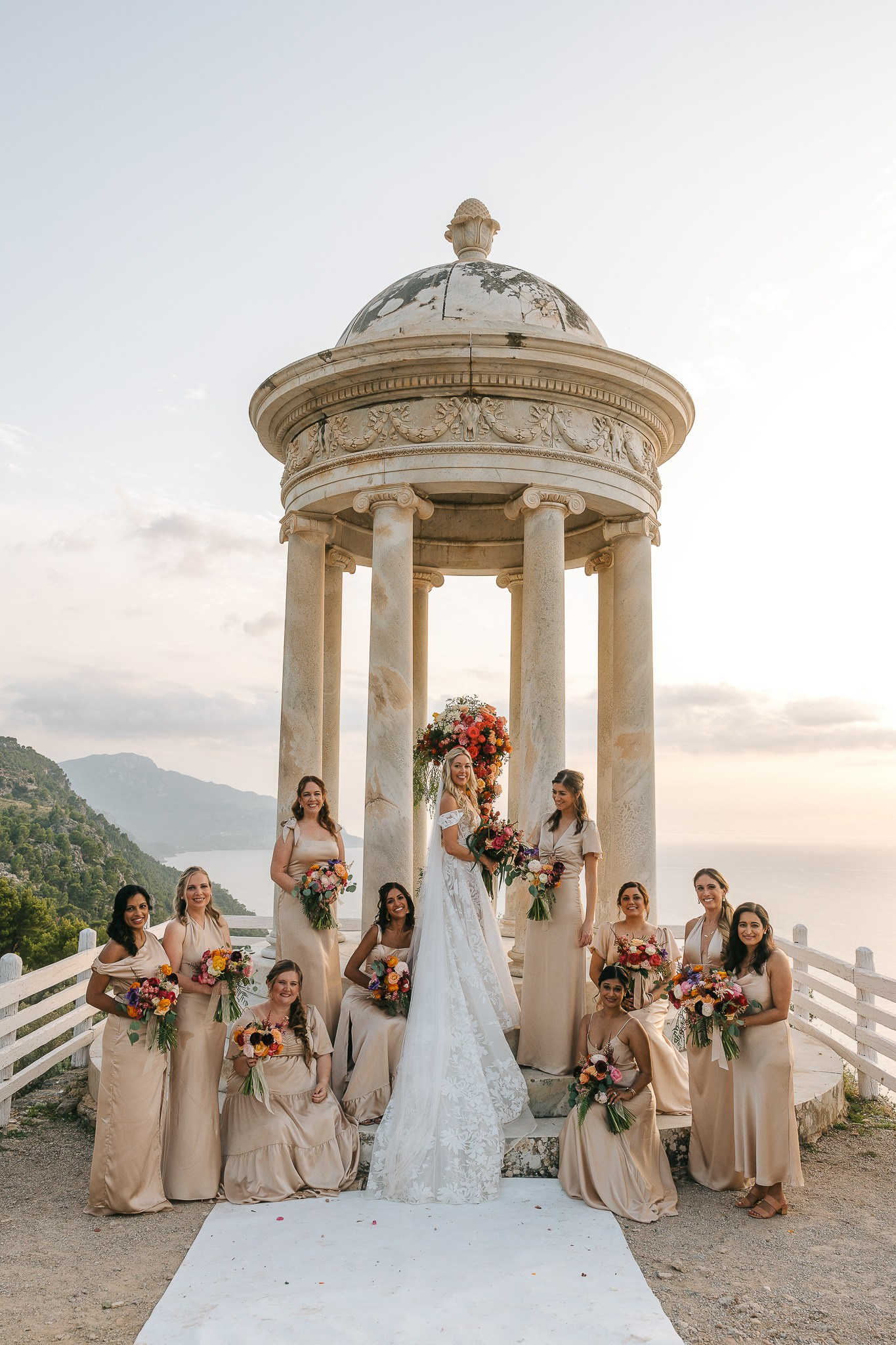 Bride surrounded by her bridesmaids at the Son Marroig temple during her destination wedding