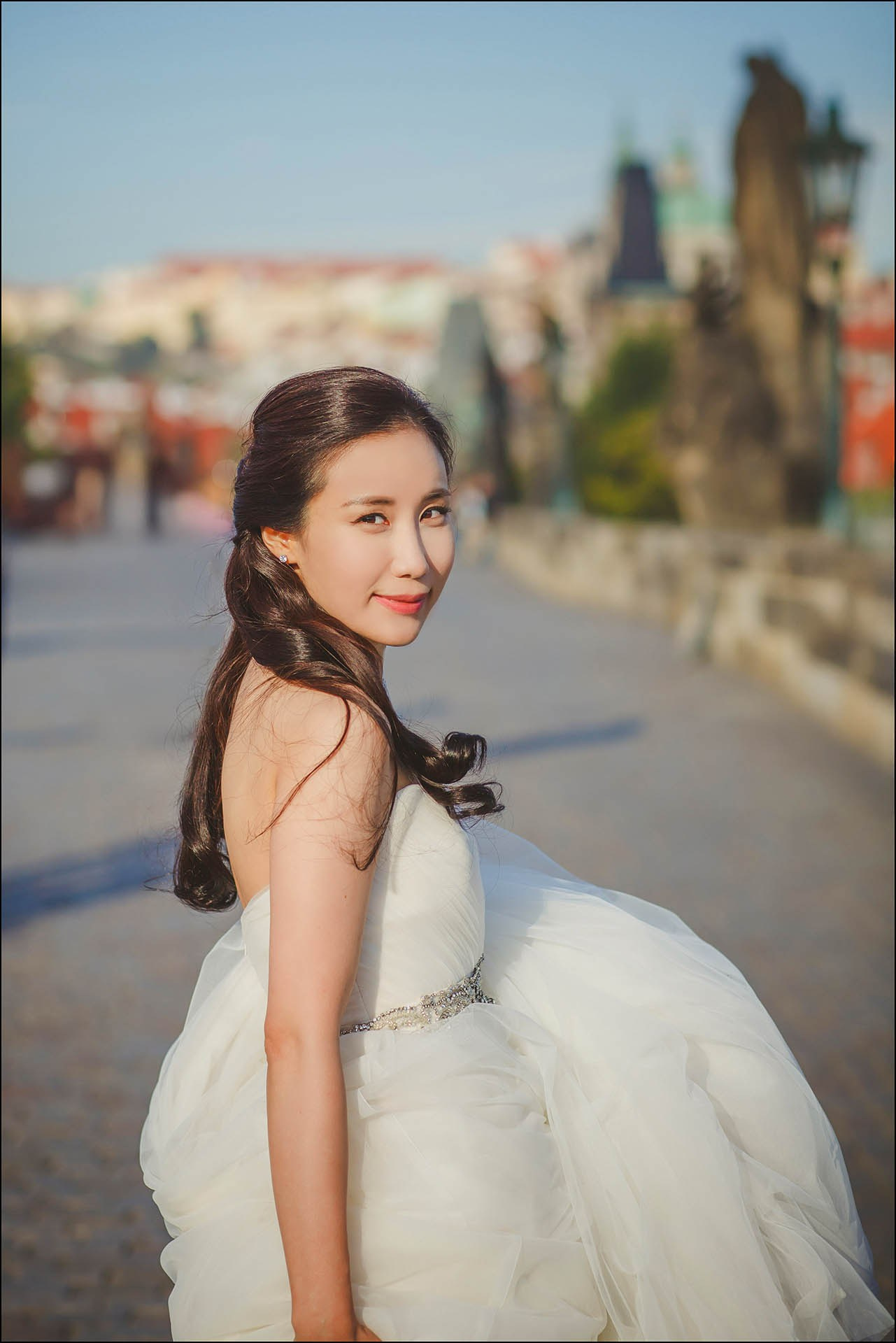 Catherine over-shoulder glance Charles Bridge wedding dress portrait.