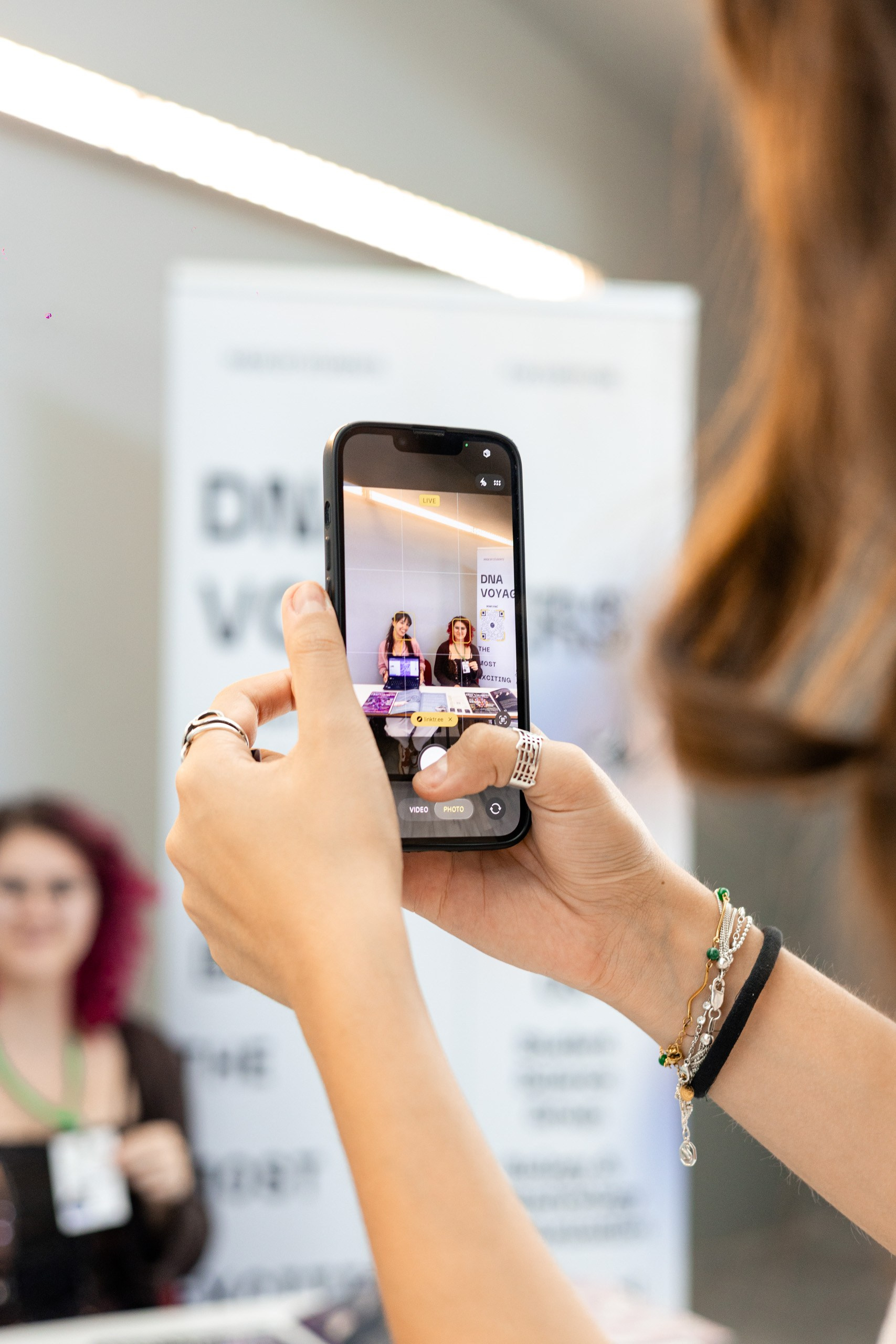 Attendee photographing a conference presentation