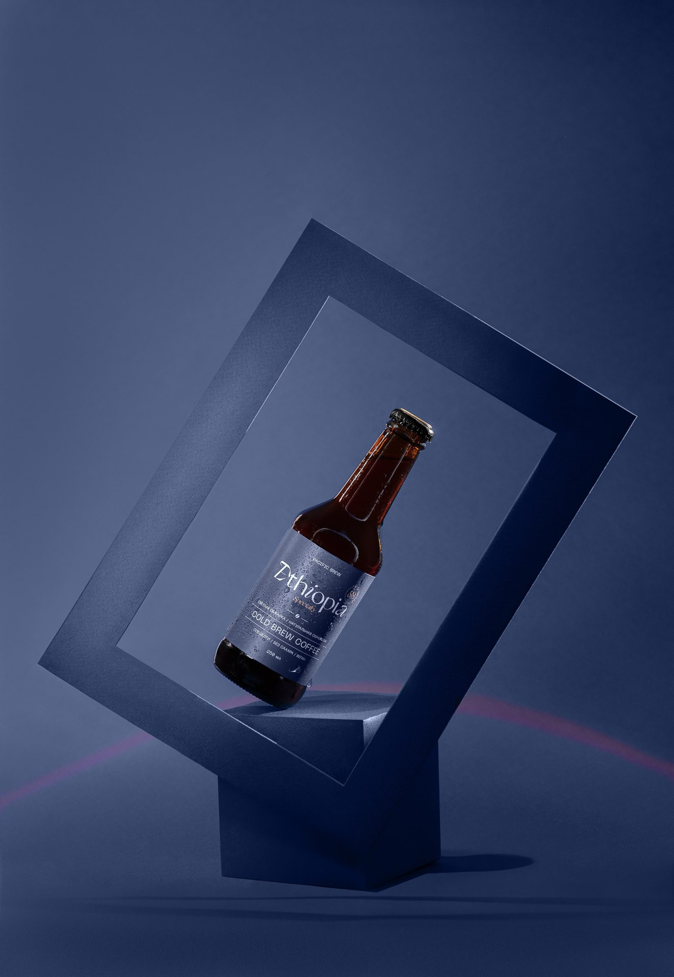 Product photography of bottle on geometric stand, studio lighting