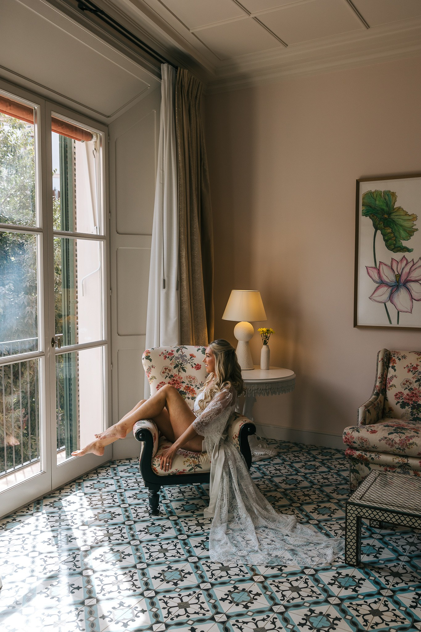 Bride sitting by the window in her getting-ready suite before her Mallorca wedding