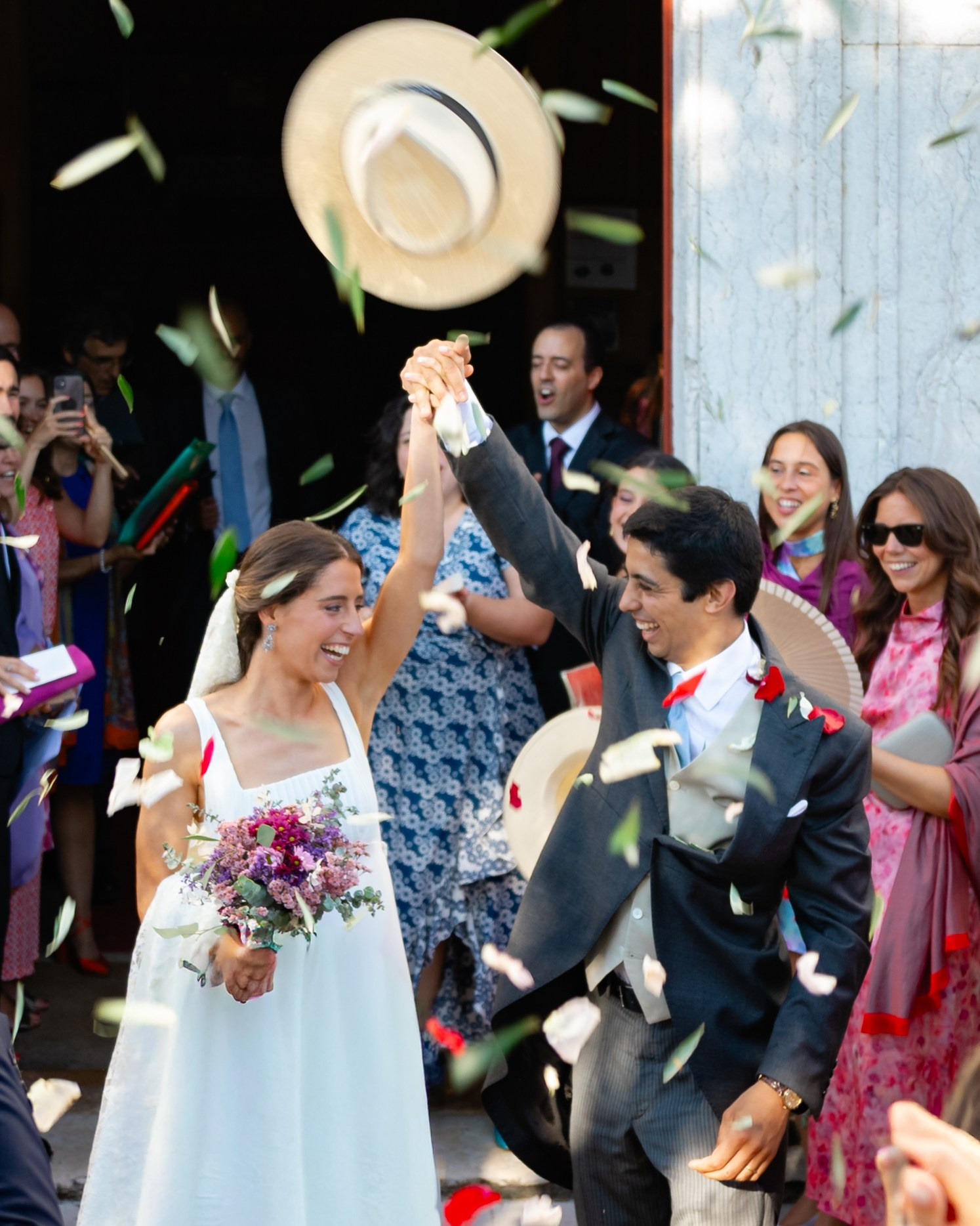 Wedding party throwing confetti and cheering outside a Portuguese venue
