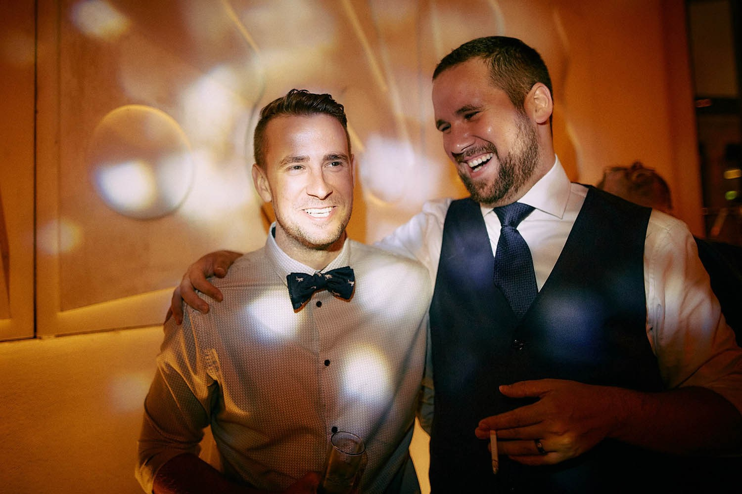 Groom and friends joking cheering over bouquet catch implications.