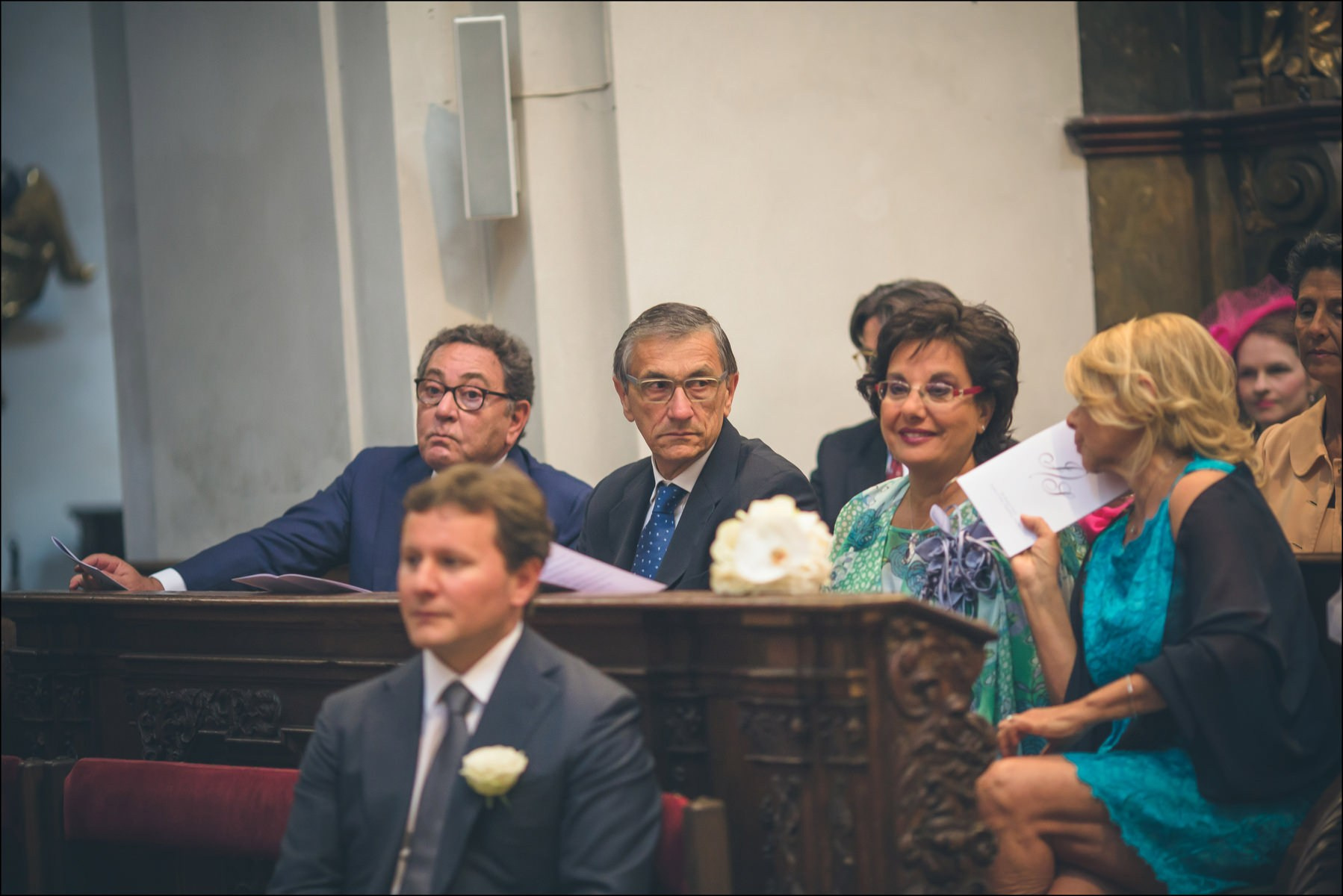 Happy family members watching newlyweds at Prague church wedding