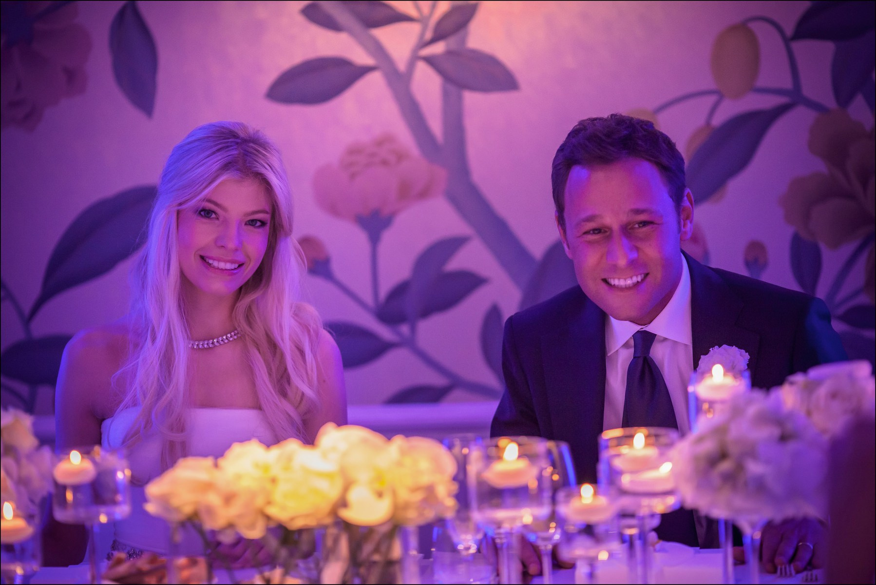 Newlyweds seated in candlelight head table Four Seasons Prague reception