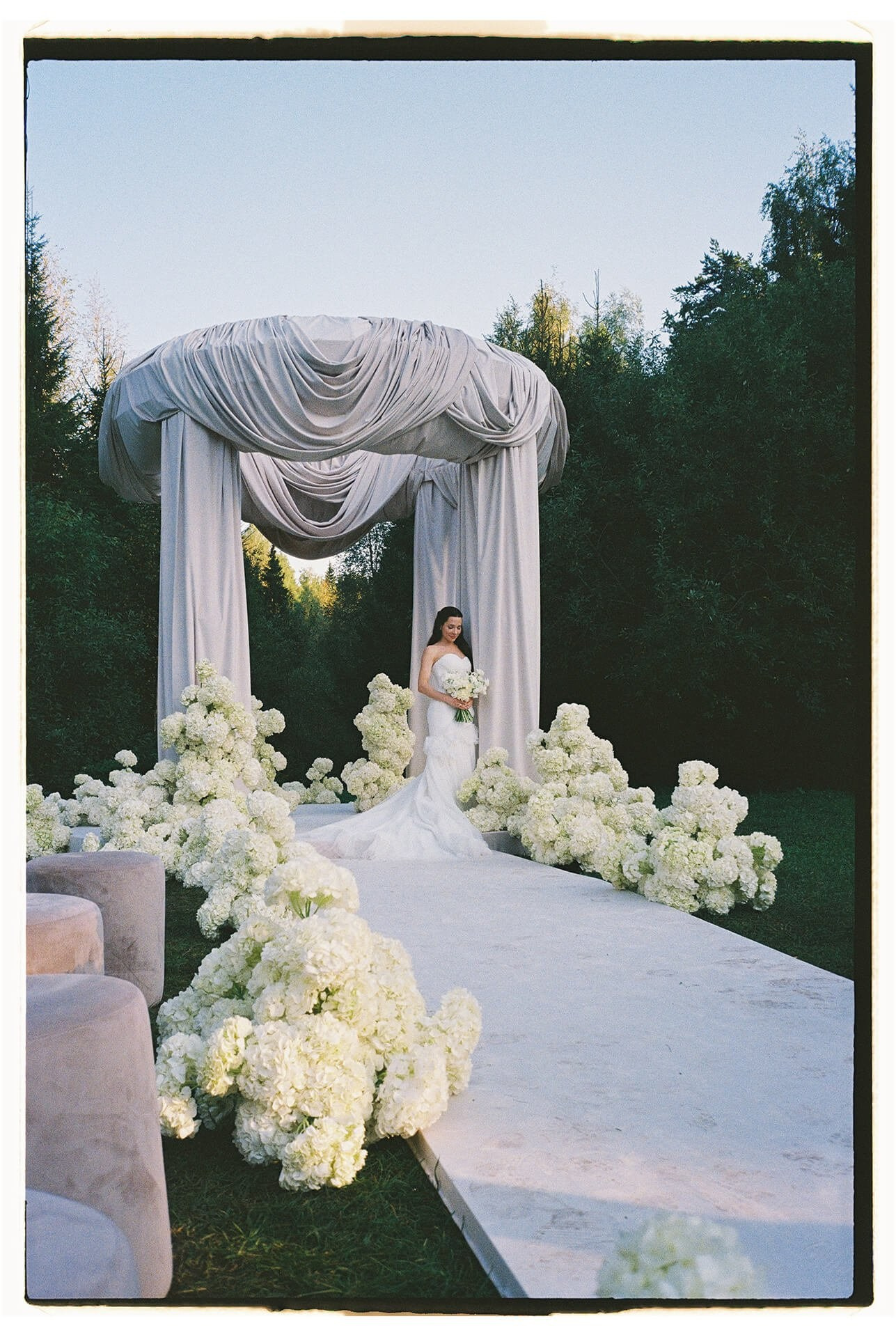 Bride holding bouquet on aisle, luxury wedding ceremony with white florals