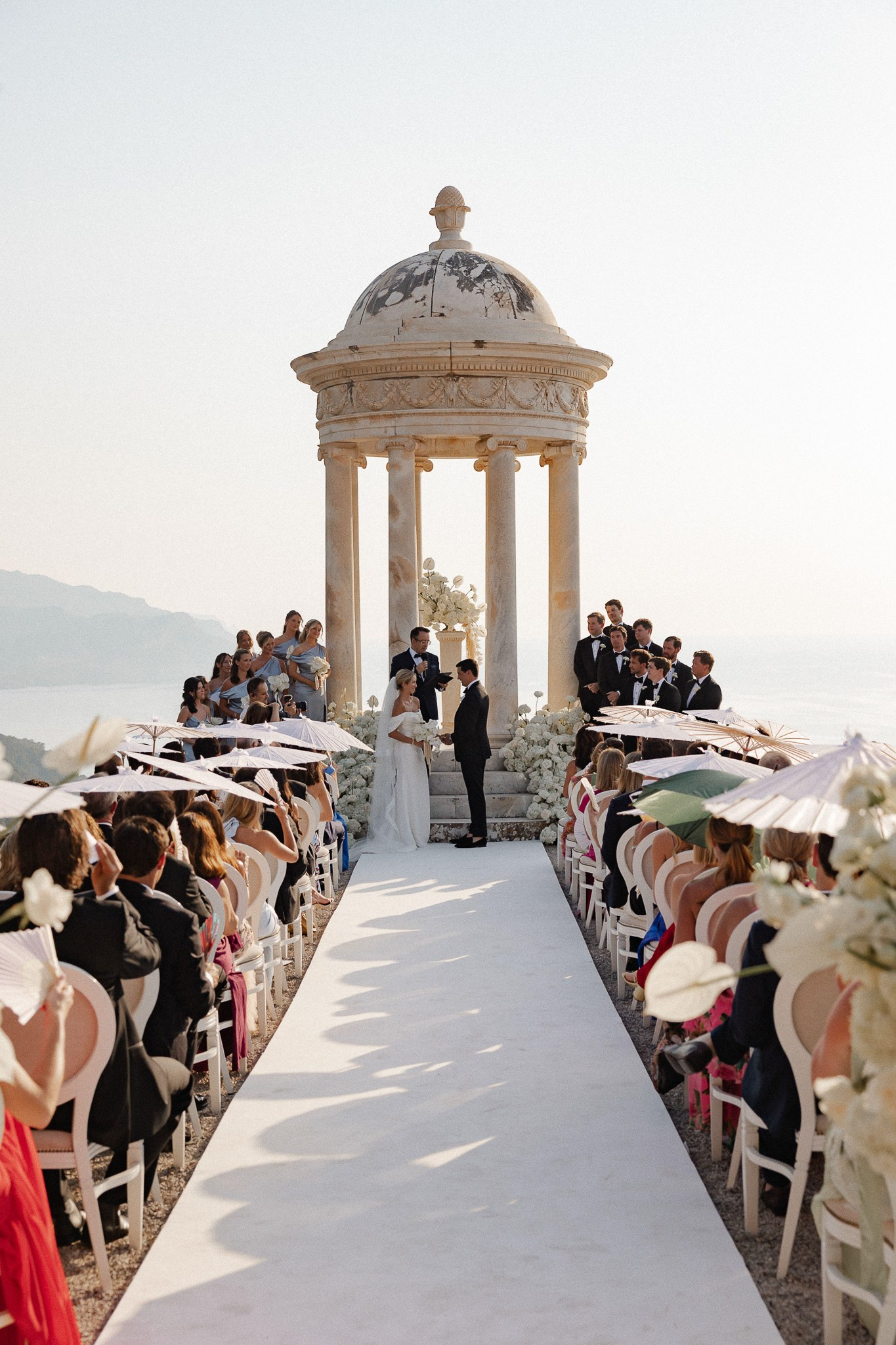 Bride and groom exchanging vows with their destination wedding officiant at the Son Marroig temple overlooking the se