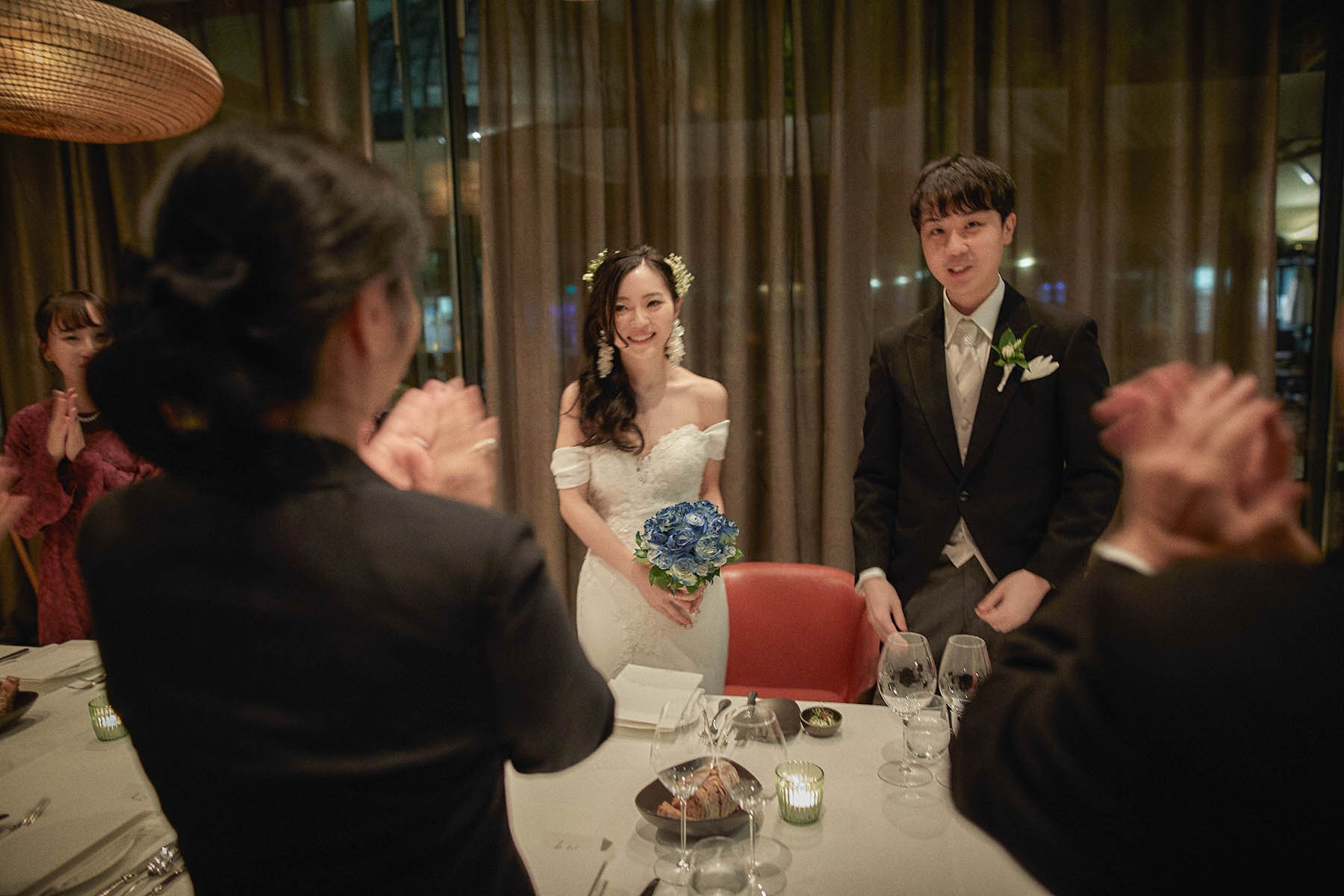 Beaming newlyweds greeted by family at restaurant arrival Vienna.