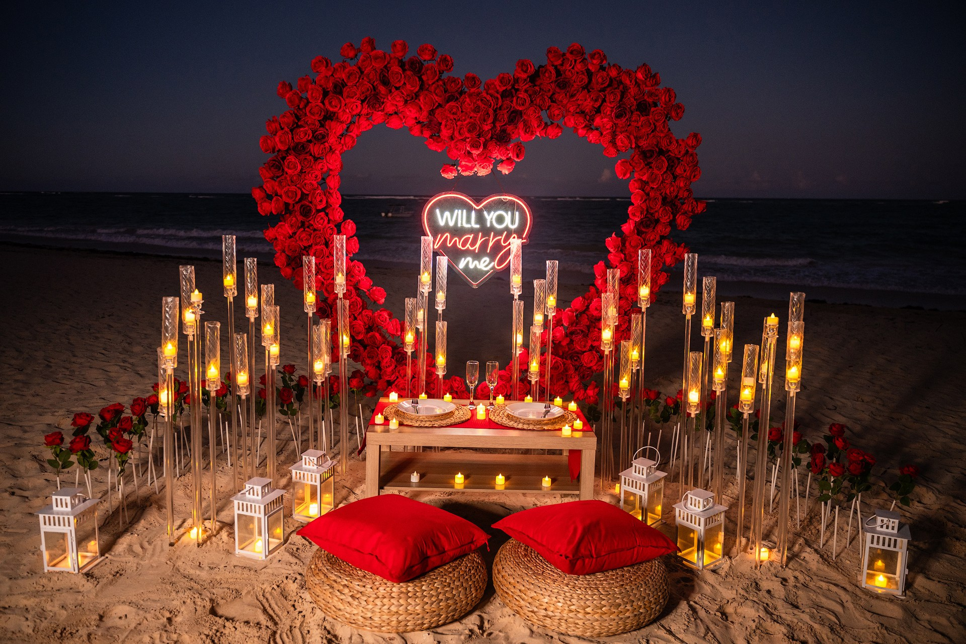 A romantic Marriage Proposal at sunset under a large heart-shaped flower arch.