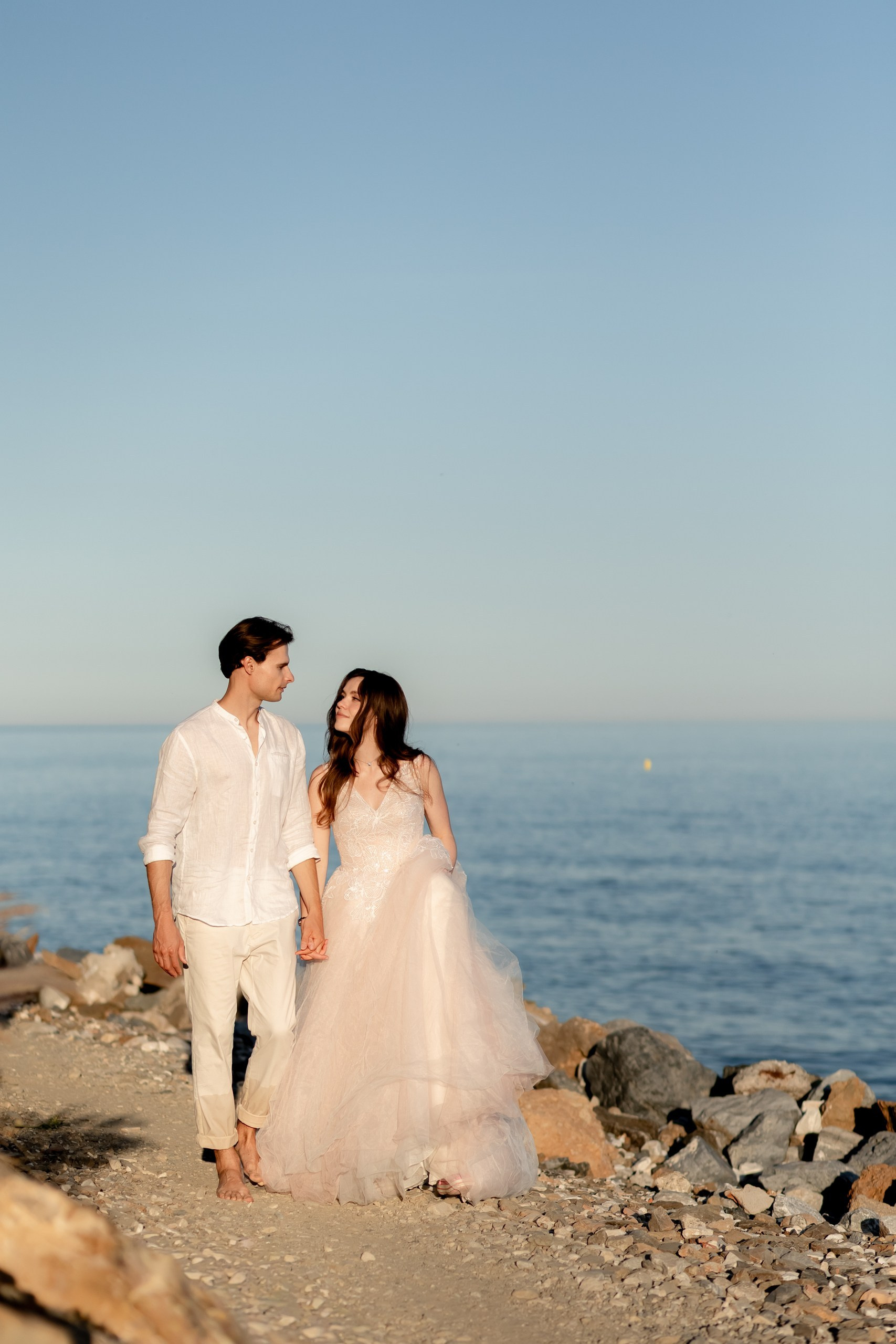 Brautpaar steht auf Felsen am Mittelmeer, Küsst sich, Abendhimmel, After Wedding Shooting Costa Blanca Torrevieja