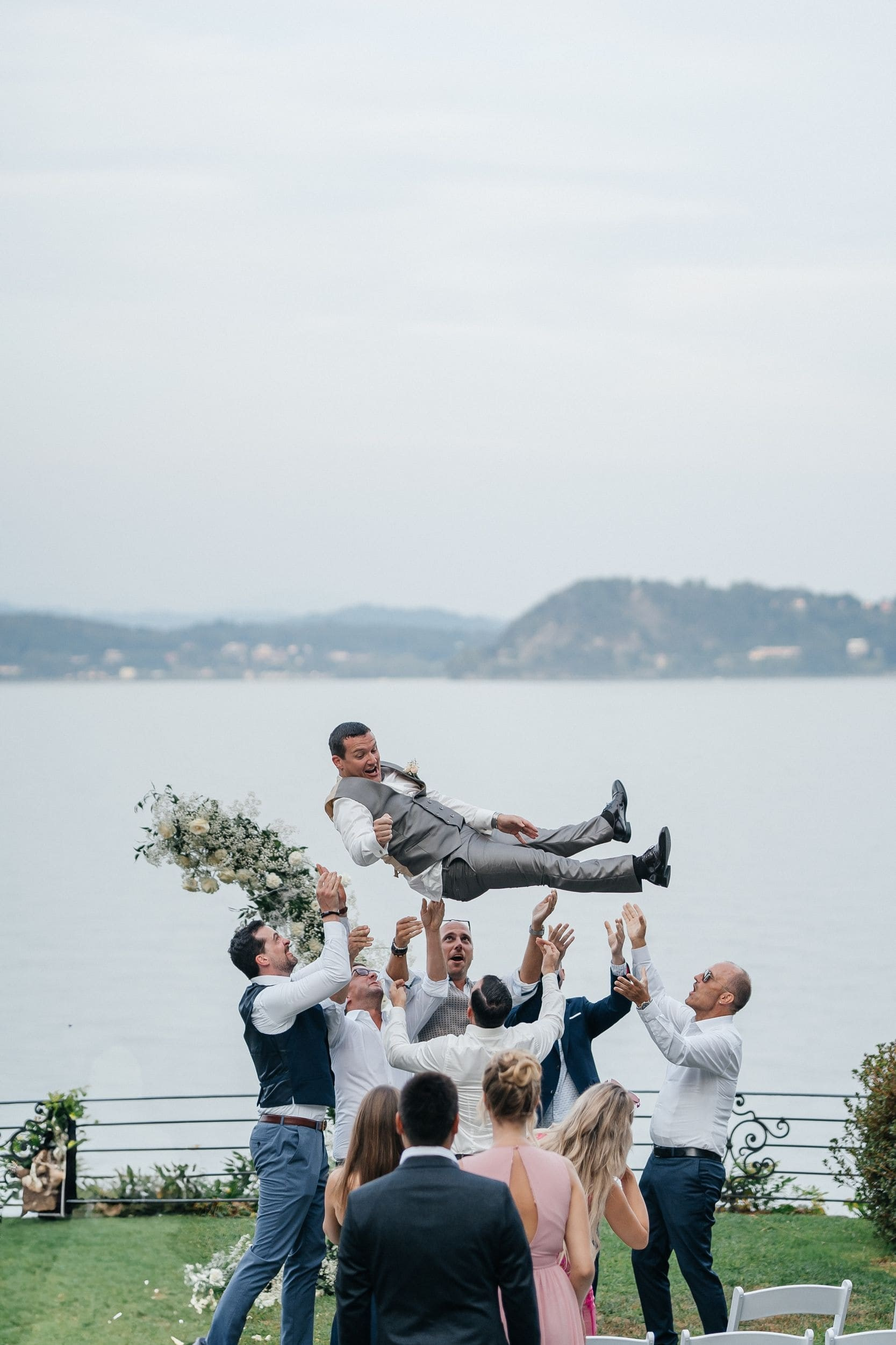 guests throwing the groom in the air