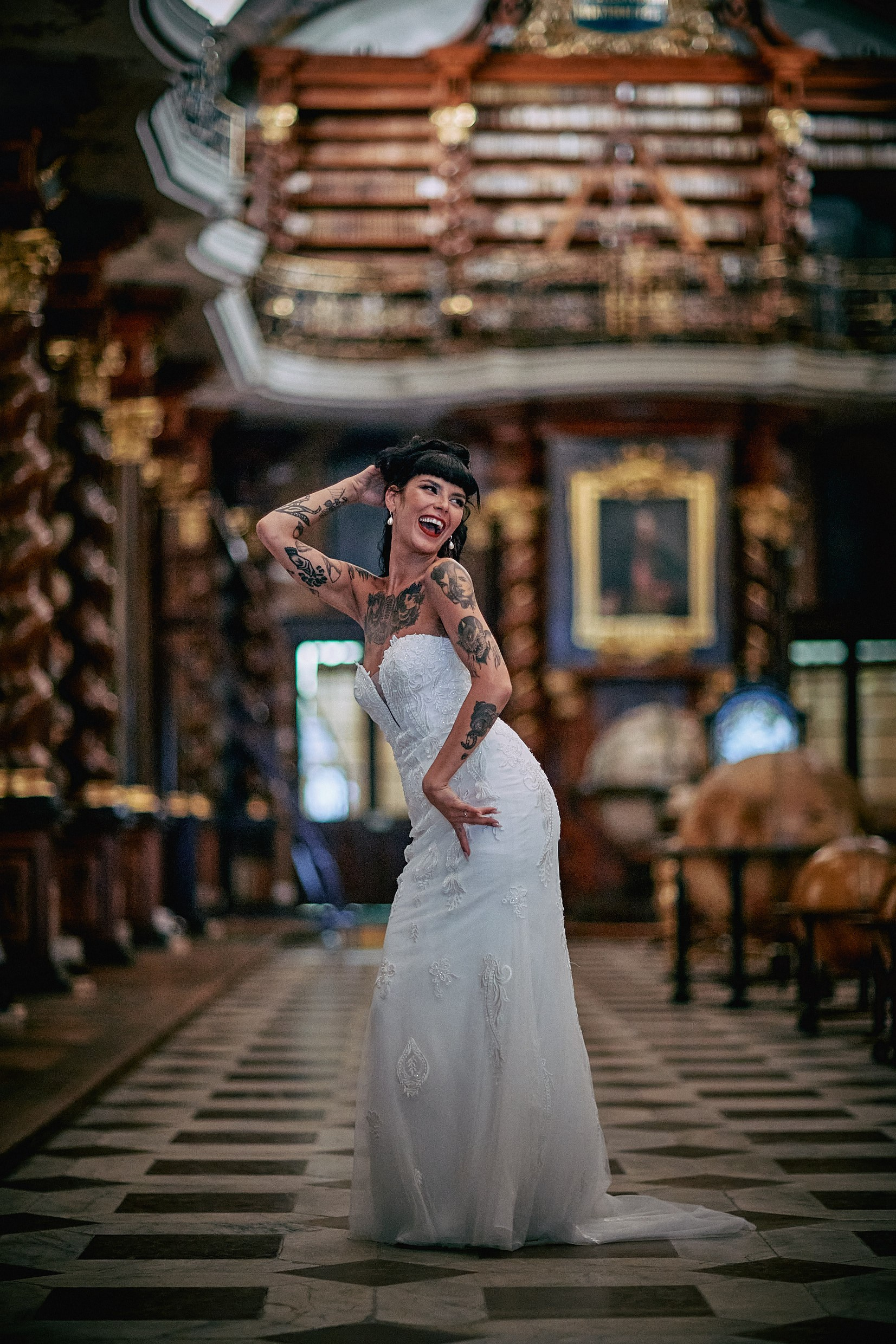 Tattooed bride intense glamorous stare in moody Klementinum setting.