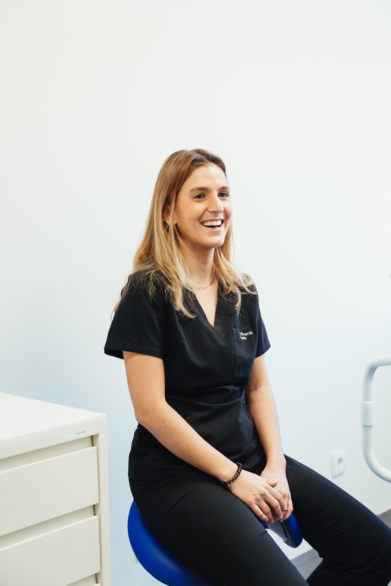 Fotografia de retrato corporativo de uma profissional de medicina dentária a sorrir num consultório moderno, captada pela Khave Media