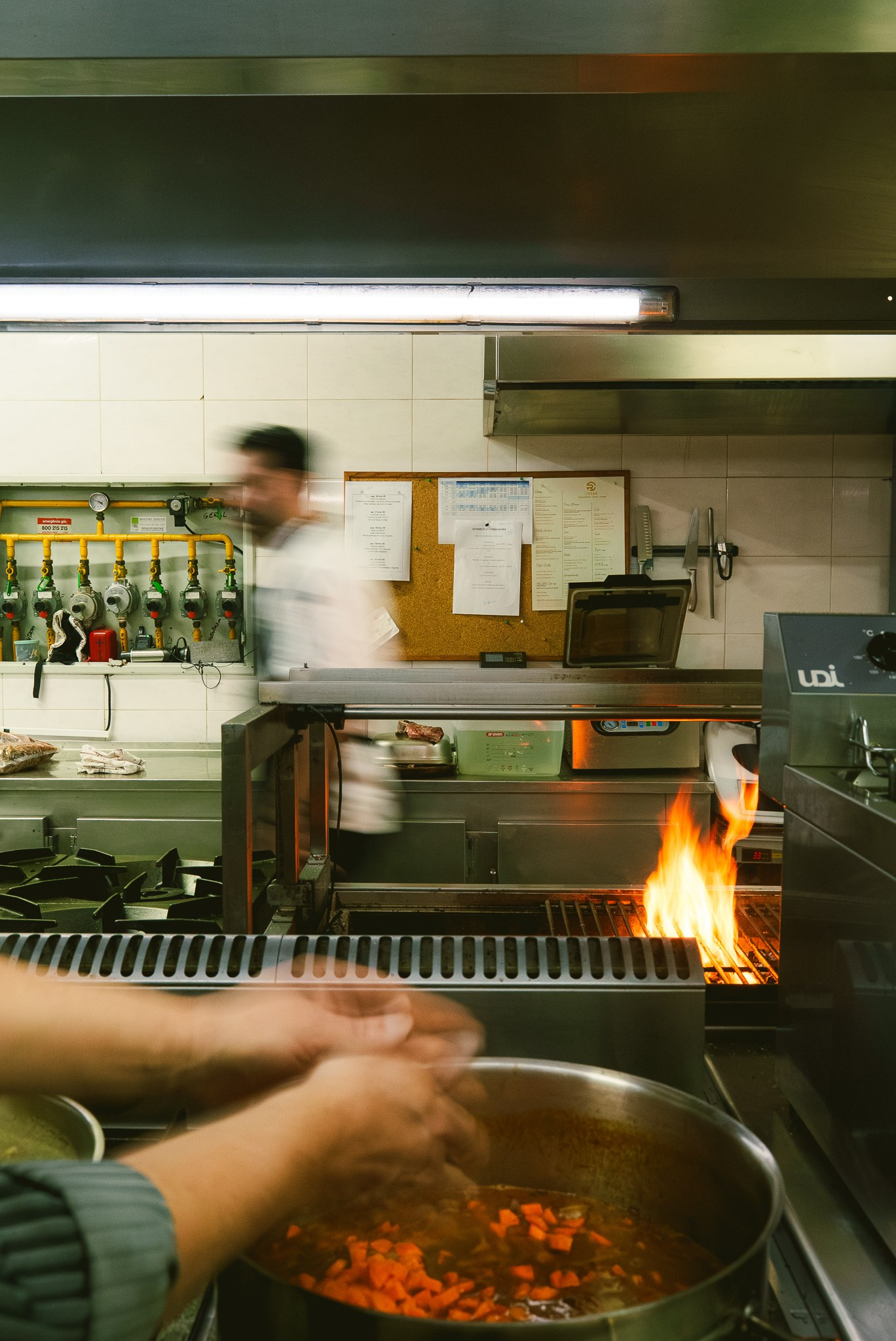 Fotografia de bastidores de cozinha profissional com chef em confeção de pratos num restaurante, produzida pela Khave Media