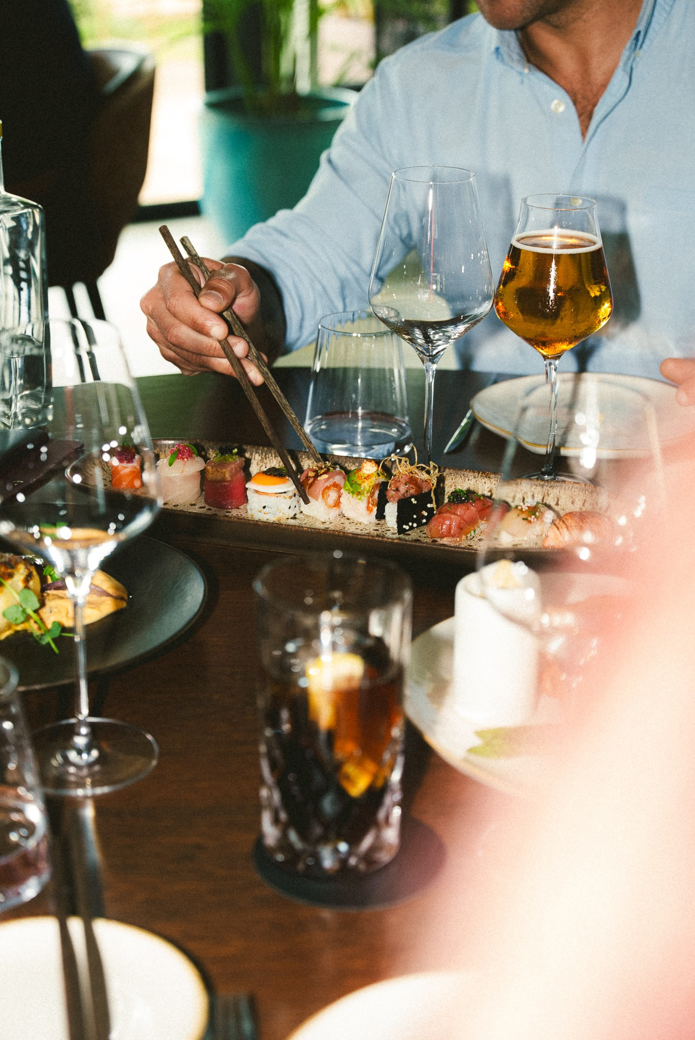 Fotografia de gastronomia japonesa de uma pessoa a comer sushi com pauzinhos numa mesa de restaurante, captada no norte de Portugal pela Khave Media