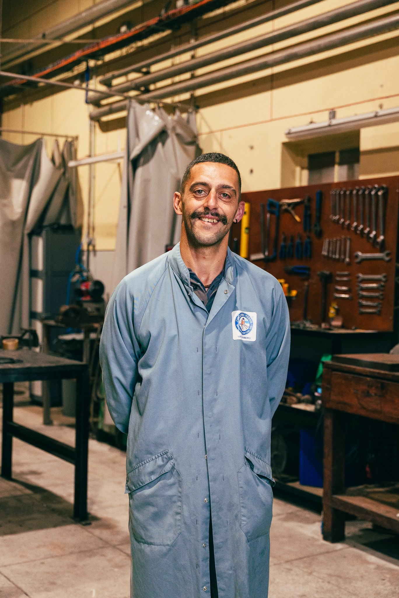 Fotografia corporativa e industrial de um trabalhador de bata cinzenta numa fábrica tradicional de conservas, produzida pela Khave Media