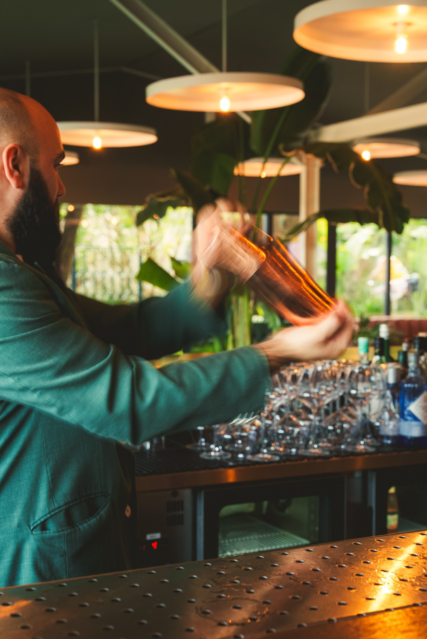 Fotografia de coquetelaria de um bartender a preparar cocktails com um shaker no bar de um restaurante, produzida pela Khave Media