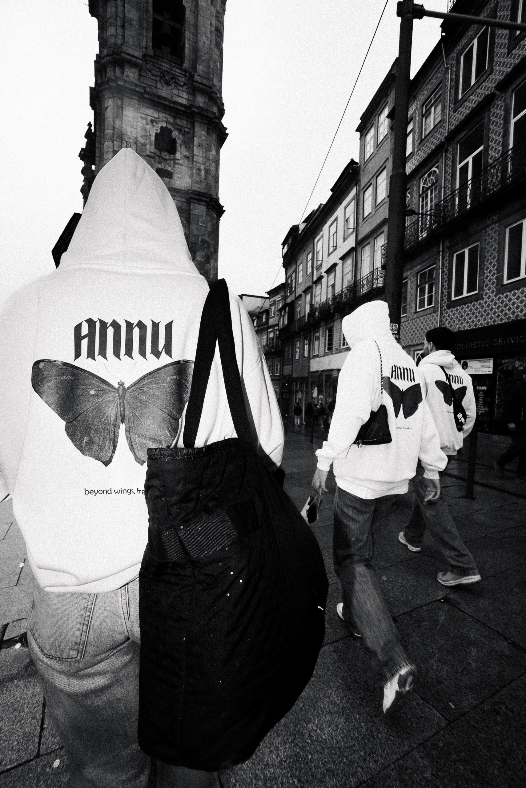 Fotografia de moda de rua (streetwear) de jovens com hoodies personalizados numa rua histórica, produzida pela Khave Media no norte de Portugal
