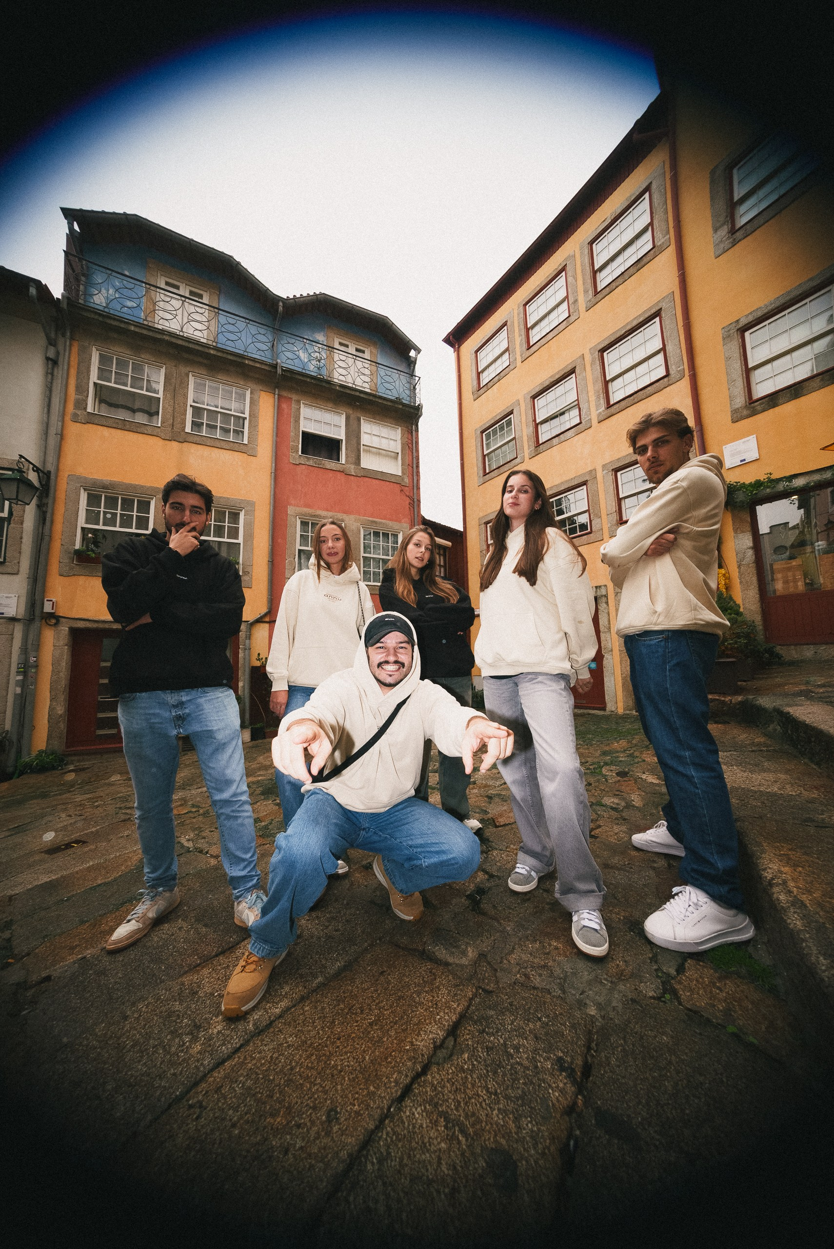 Fotografia urbana de grupo com efeito olho de peixe de jovens a posar numa rua histórica, captada pela Khave Media