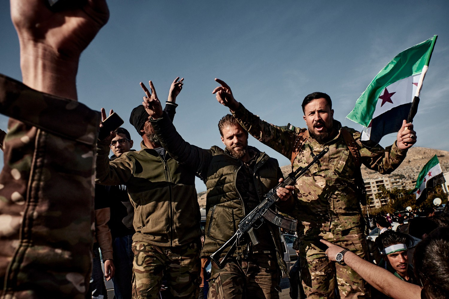 Damas, 15 décembre 2024 – Des rebelles du groupe islamiste Hayat Tahrir al-Sham ayant participé à l'offensive conduisant au renversement de Bachar al-Assad, lors d'un rassemblement sur la Place des Omeyyades pour célébrer la chute de la dictature. Les nouveaux héros, pour la plupart originaires d'Idlib, partagent ce moment d'euphorie nationale au milieu des foules en liesse.