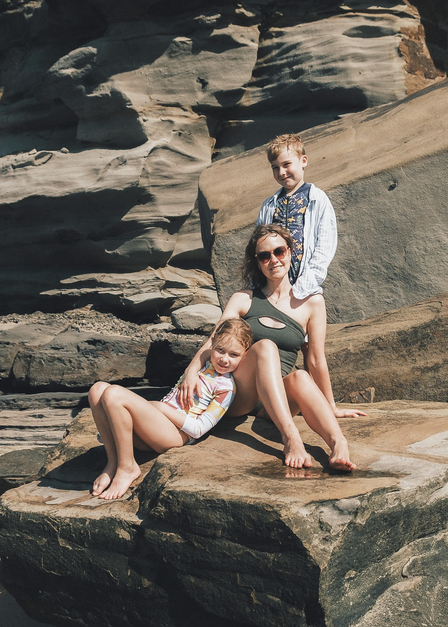 Parents playing with their child by the ocean, natural family beach photoshoot.