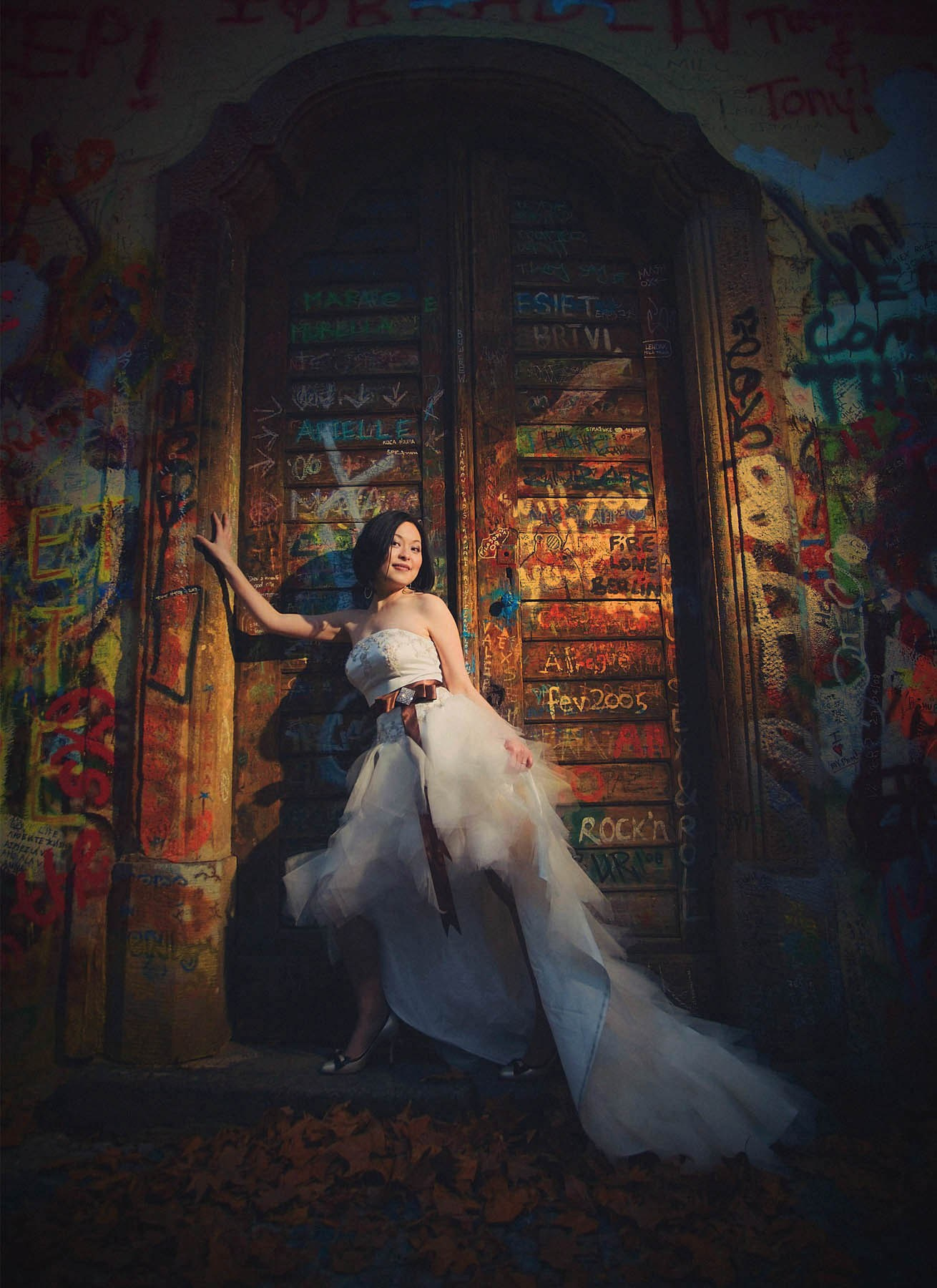 Beautiful Chinese woman striking a pose at the John Lennon Wall, Prague