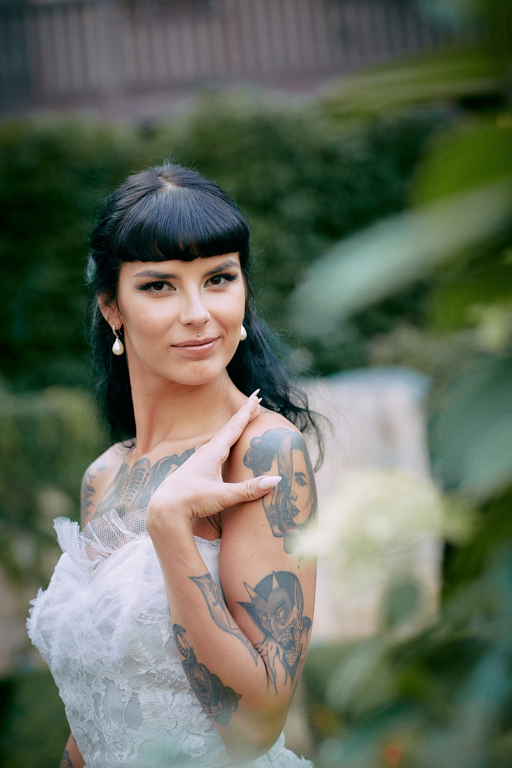 Burlesque bride confident striking pose in luxurious hotel garden.