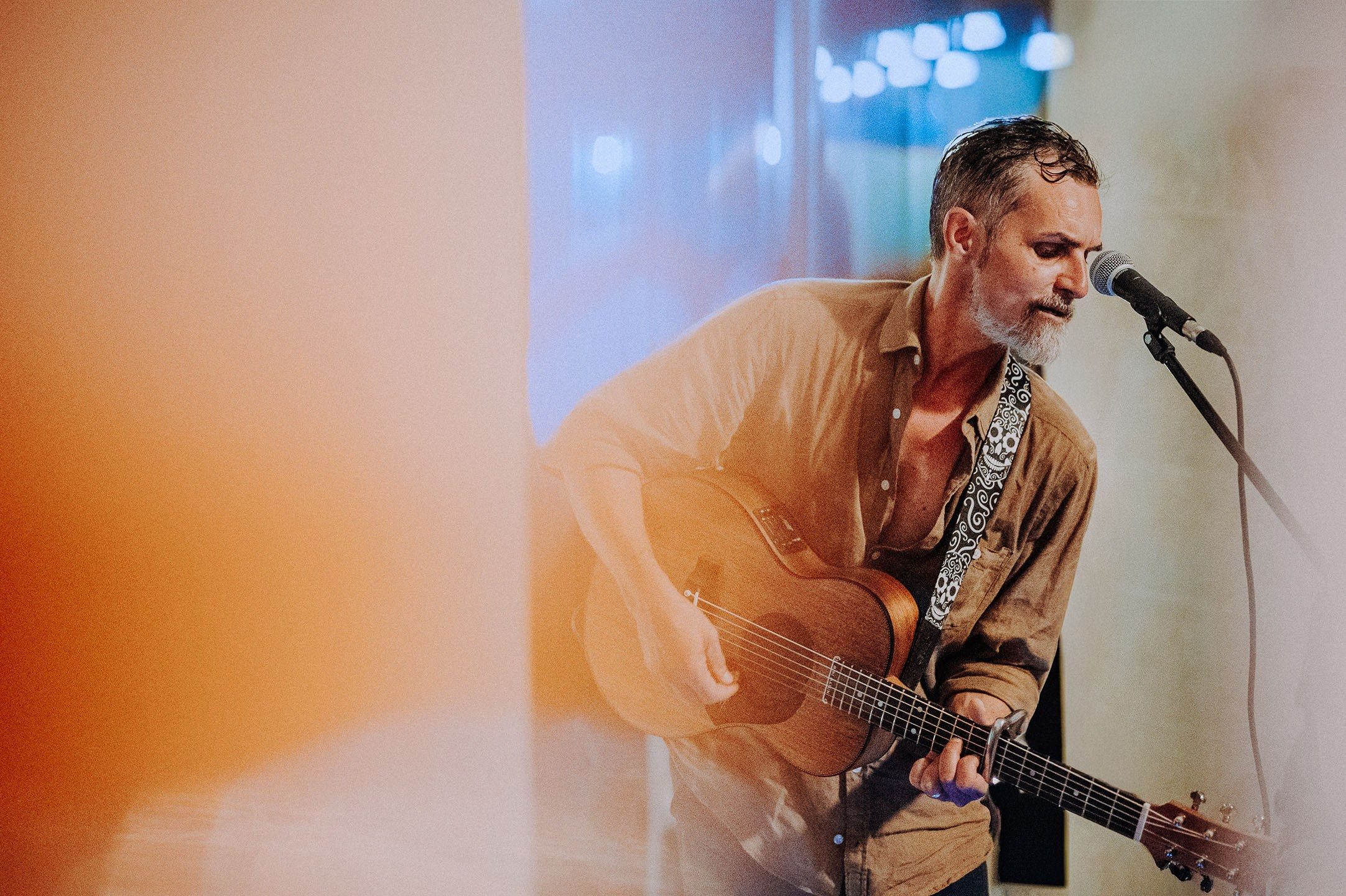 Solistul Padre de la formația Picuri de Foc cântând la chitară acustică și microfon în concert, foto Photosinteza