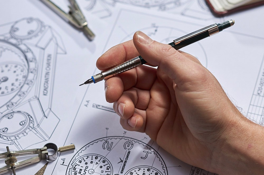 Рука с карандашом над чертежом и чертежными инструментами - фотограф Андрей Дунин