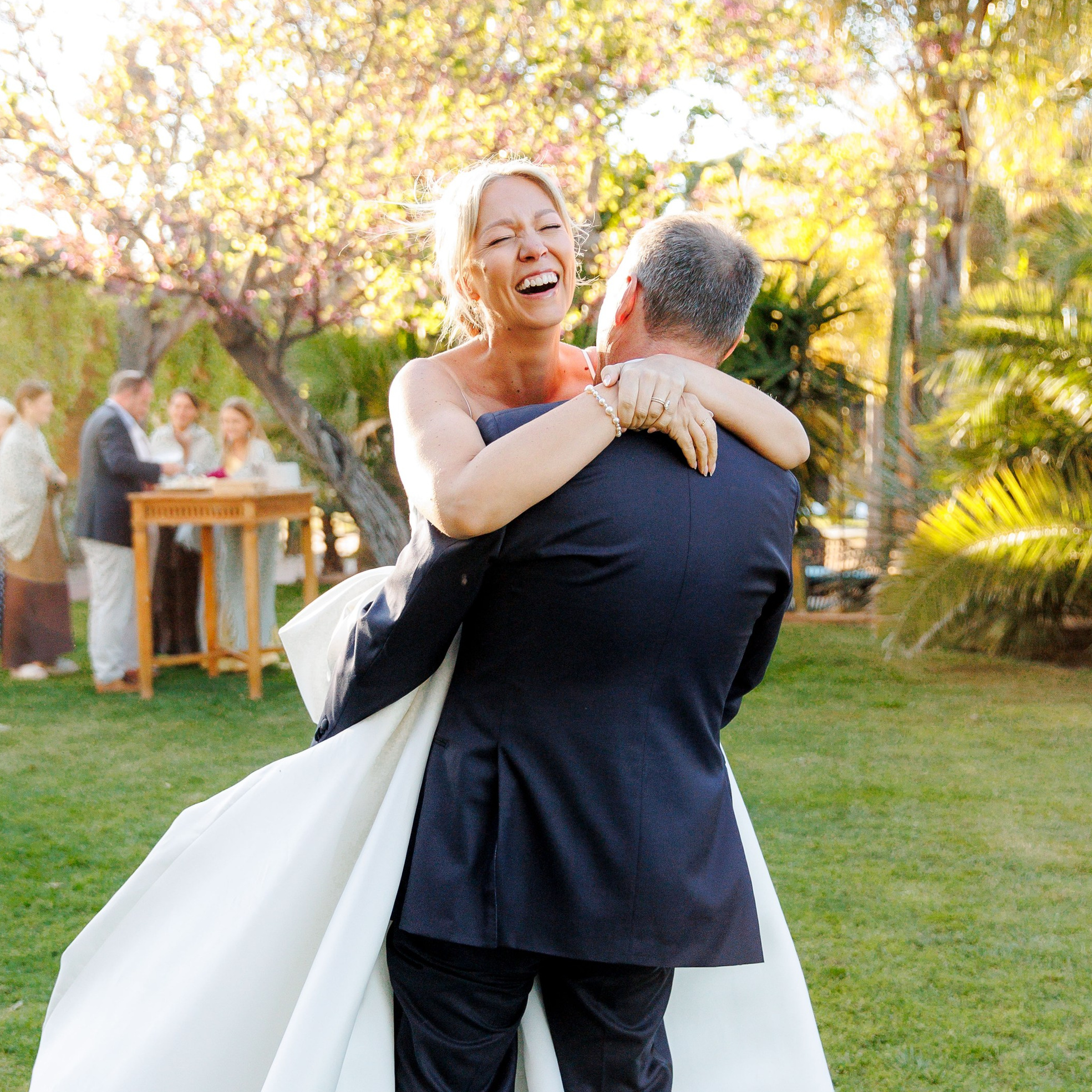 Groom giving a hug and twist to the bride after the cocktail hour 