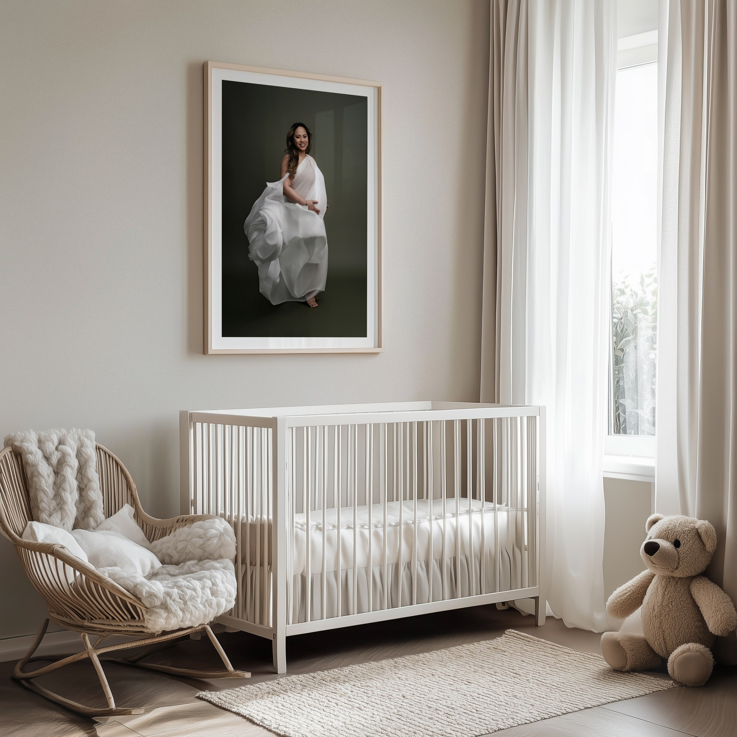 Framed maternity portrait hanging on a nursery wall above a cot