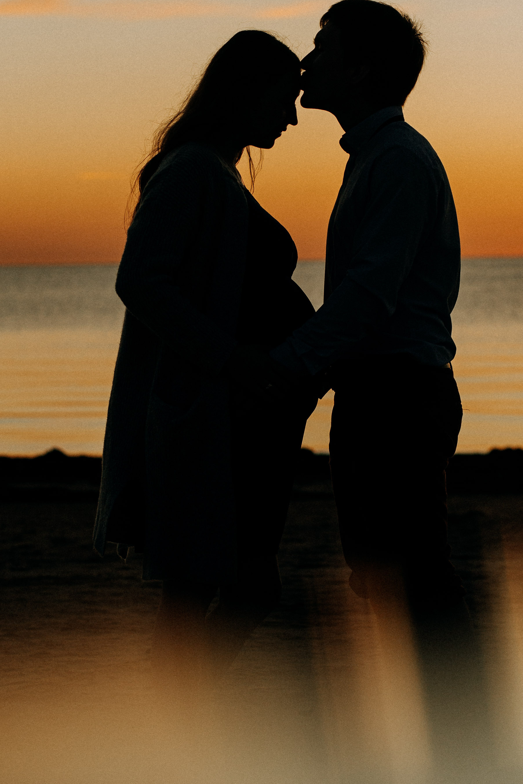 Gaidību fotosesija pie jūras saulrietā