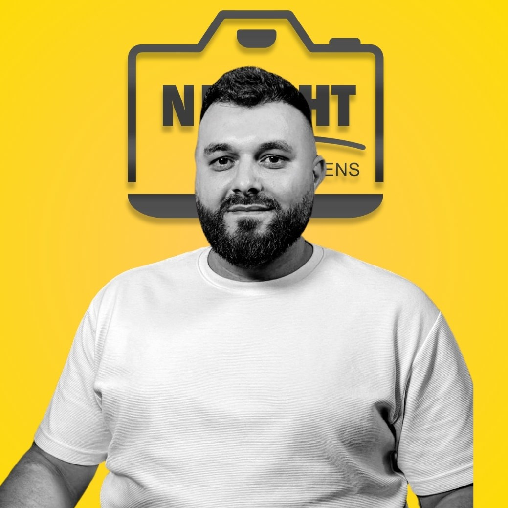 Portret profesional al unui bărbat pe fundal galben cu logo, expresie zâmbitoare