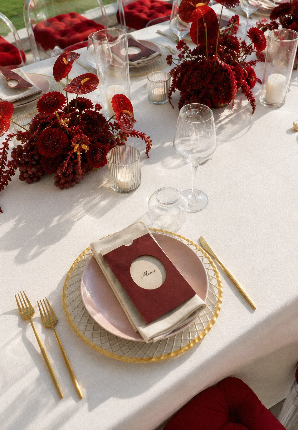 Red and white wedding tablescape with Ghost chairs and velvet cushions at a luxury Bodrum wedding