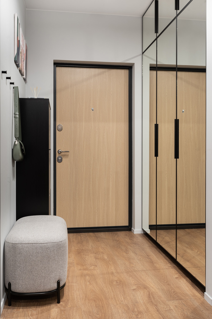 Просторная прихожая с зеркалом и зоной для обуви.