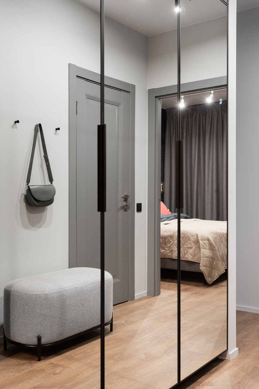 Прихожая с зеркальными дверями и зоной для хранения вещей.