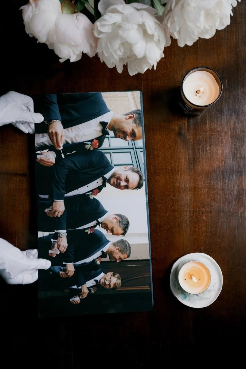 Wedding party portrait print placed beside candle on wooden table