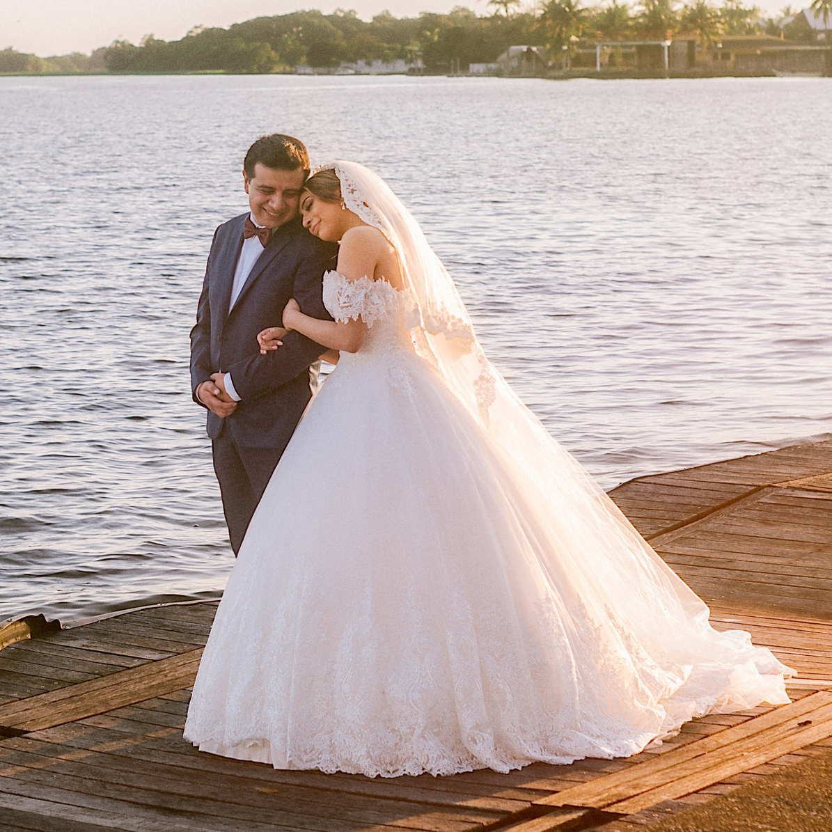 Novia con vestido blanco posando frente al lago al atardecer, fotografía de bodas en exteriores, Carlos RaGo fotógrafo de bodas México