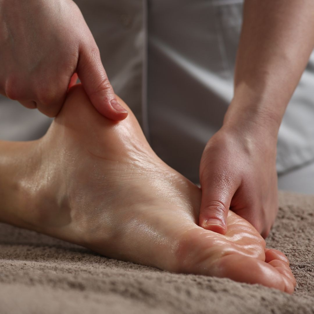 Eine Masseurin massiert die Füsse ihrer Kundin