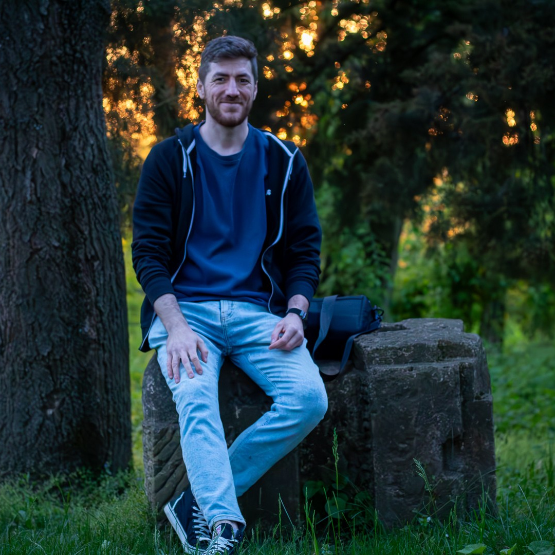 Woman in winter coat looking out over a frozen lake with snow-covered mountains in the distance