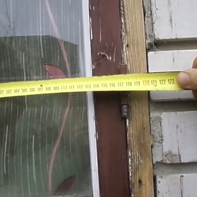 Мастер по установке пластиковых окон снимает замер на новом объекте.