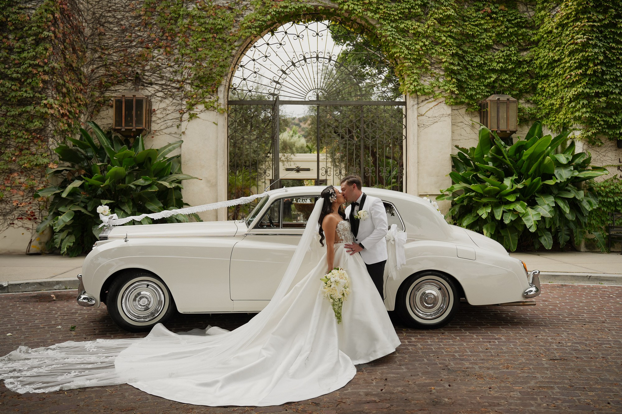 Wedding photo in front of the white retro Rolls-Royce 