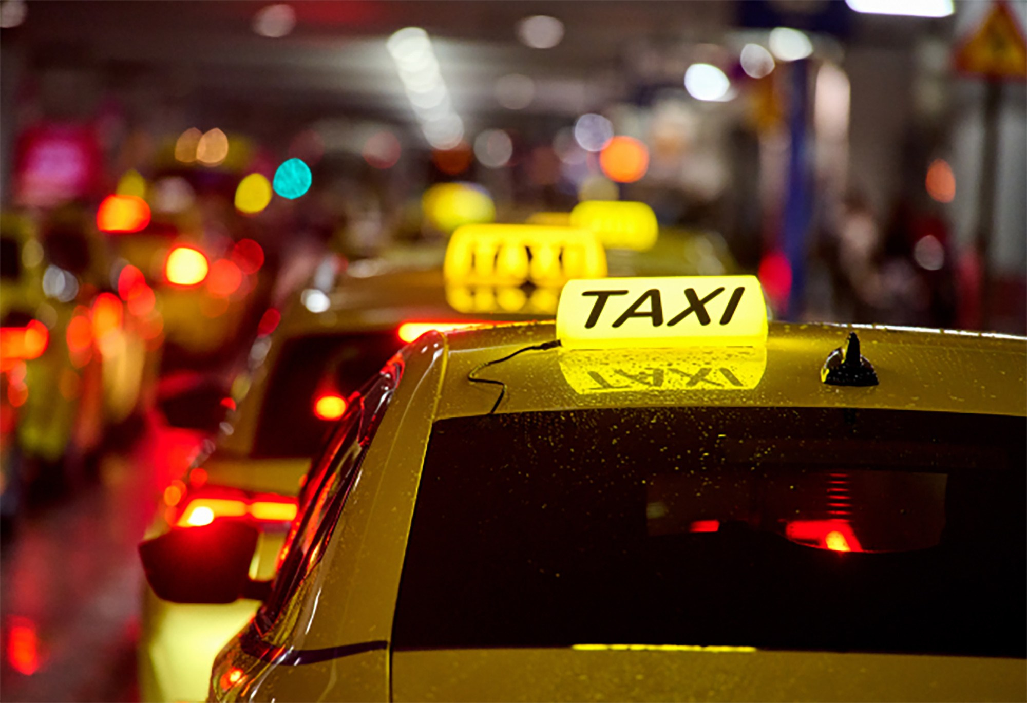Athens taxi line at night, illustrating cab service for airport transfers or city transportation.