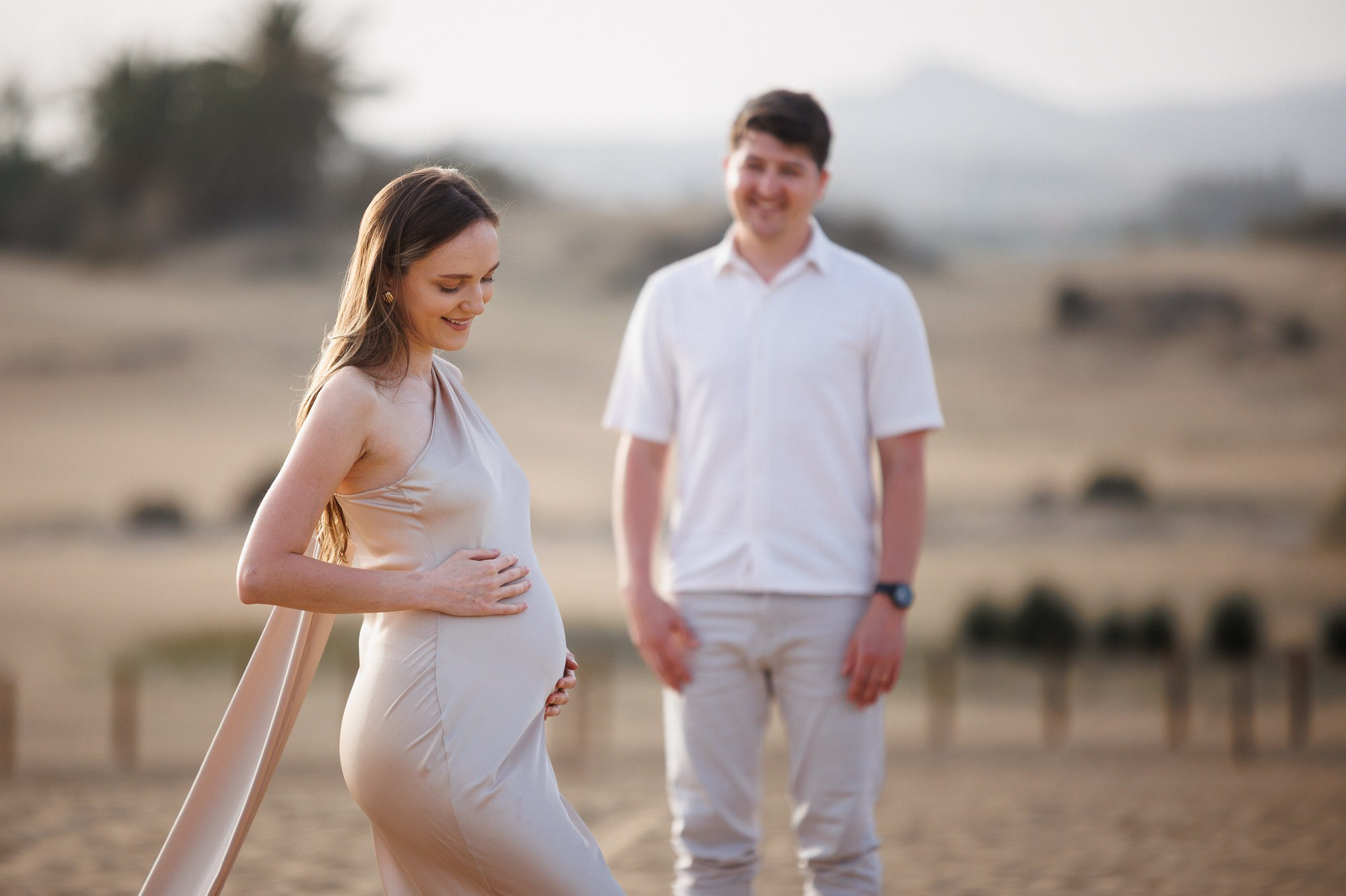 Pregnant woman and partner laughing on Maspalomas beach