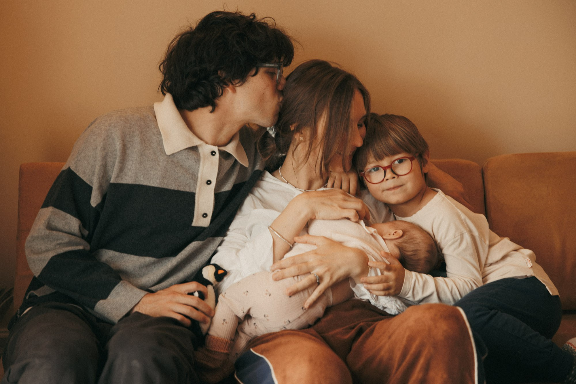 Family of four cuddling during an at-home newborn session in Montreal