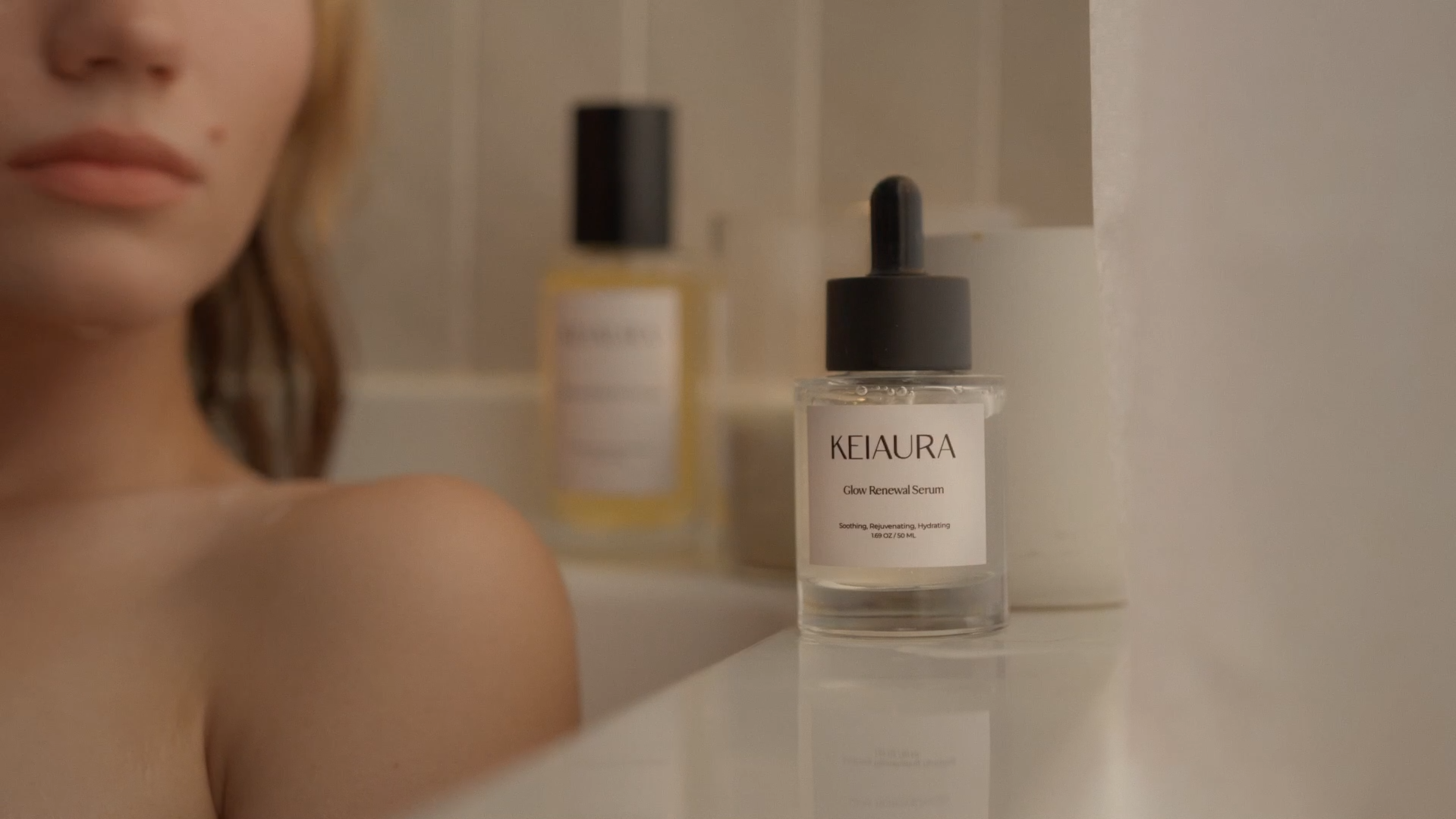 Keiaura Glow Renewal Serum featured in a refined bathroom setting with a model, emphasizing Surkov Film's expertise in crafting sophisticated visuals for beauty campaigns.