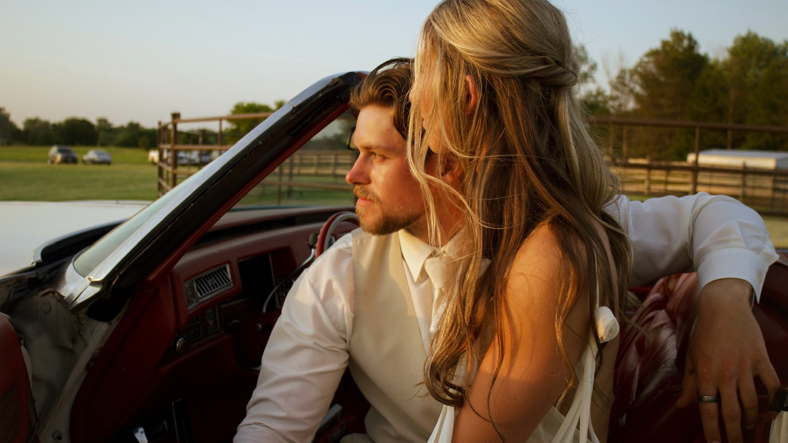Wedding videographer capturing bride and groom during golden hour.