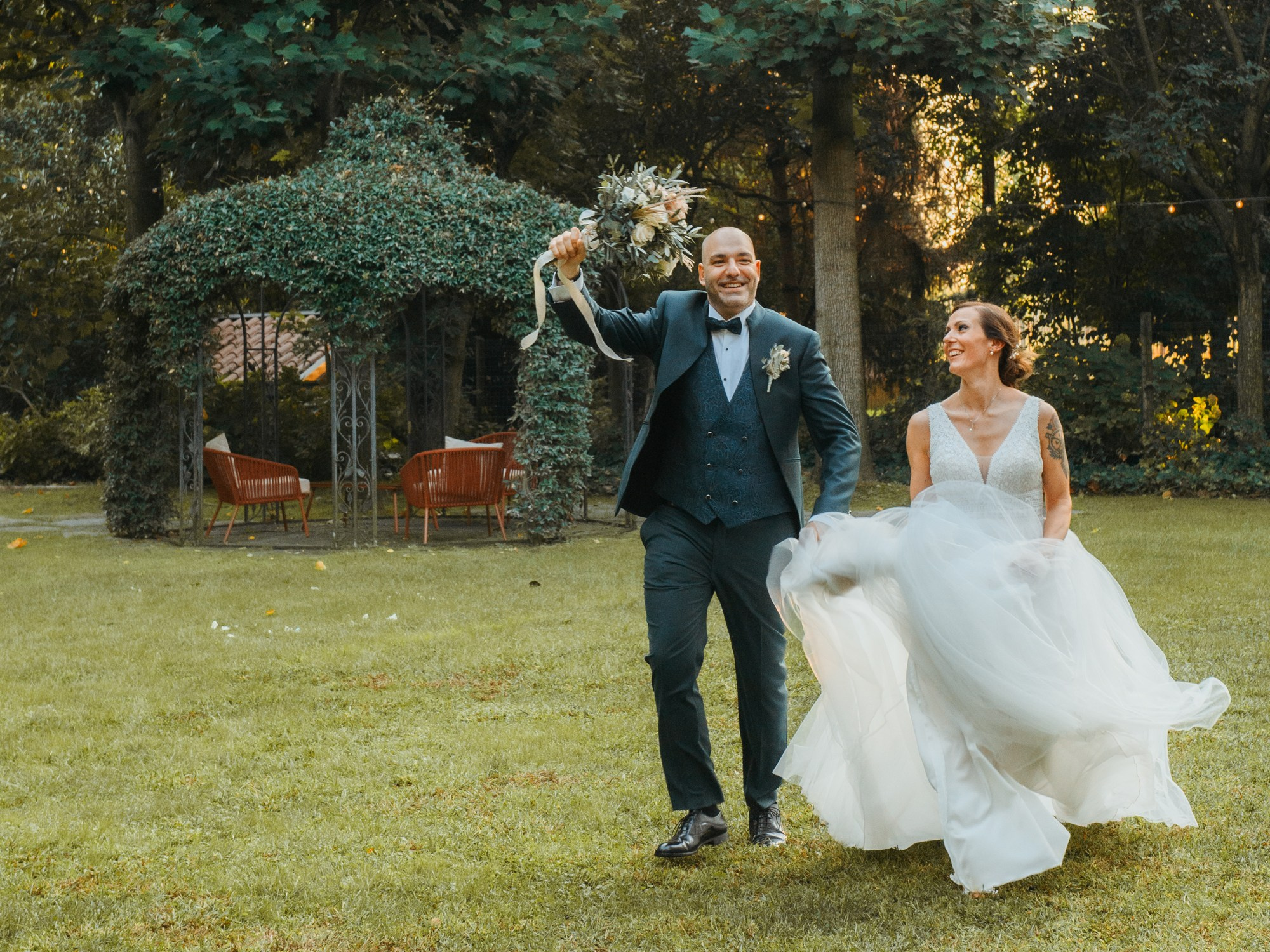 Bride and groom walking together during an outdoor wedding reception in Italy. Candid photo session wedding photographer